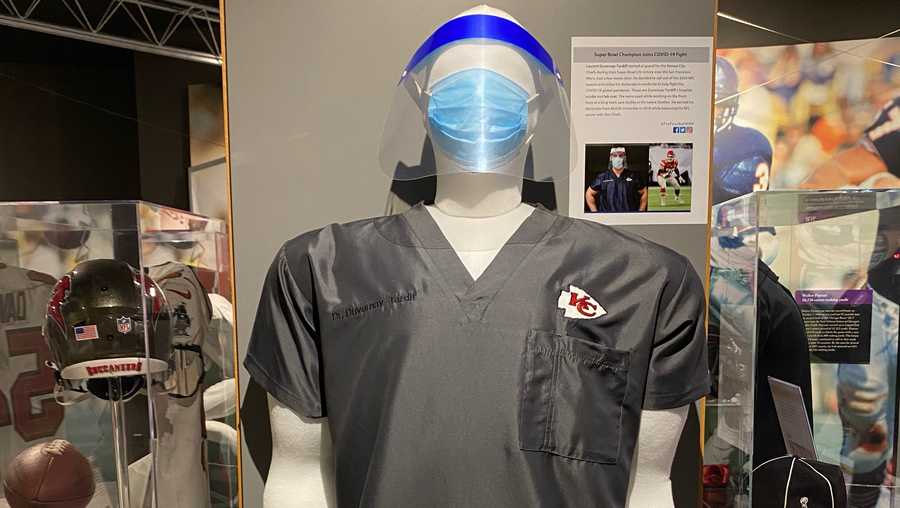 In photo tweeted by the NFL Pro Football Hall of Fame, gray scrubs with the Kansas City Chiefs logo and a white lab coat, both belonging to Chiefs' OG Laurent Duvernay-Tardif, are now on display in the Hall of Fame.