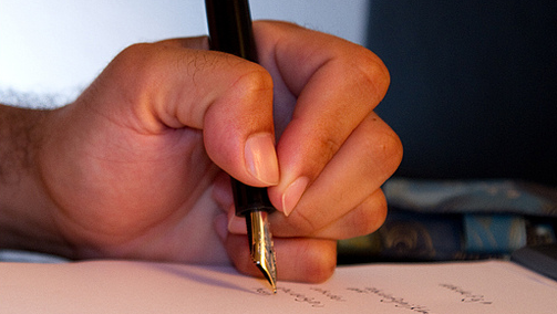 A person writes with their left hand.