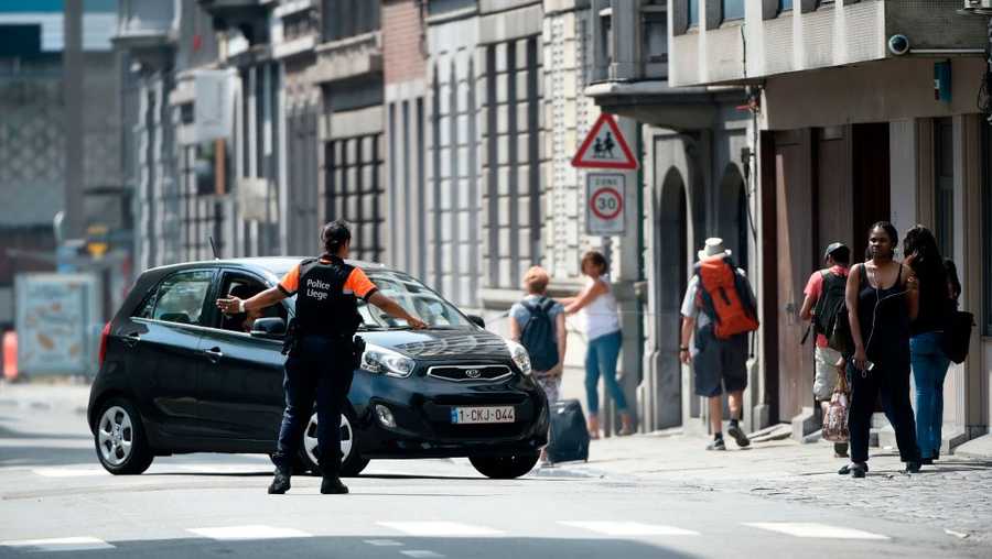 A police officer redirects a car in the eastern Belgian city of Liege on May 29, 2018, after an armed man shot and killed two police officers before being subdued by police. - 'There are two dead policemen and two others injured,' the spokeswoman for the Liege prosecutors office told AFP. 