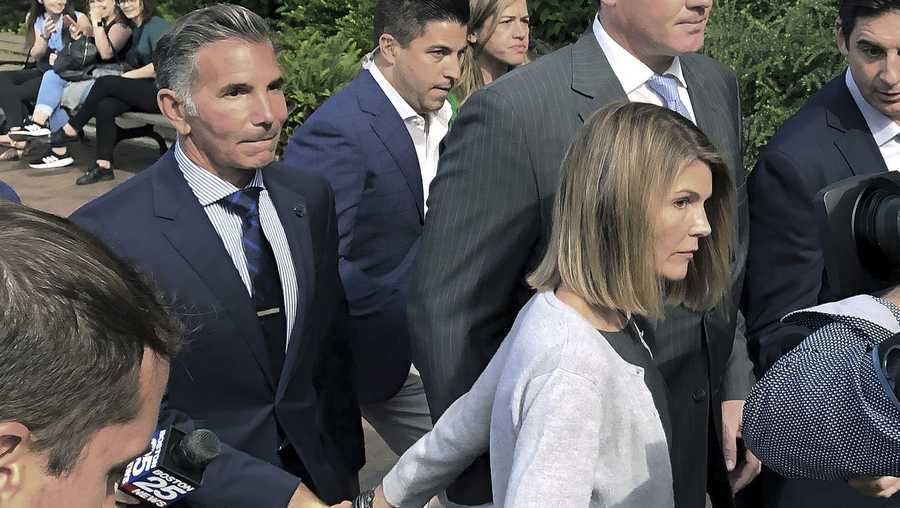 FILE - In this Aug. 27, 2019, file photo, Lori Loughlin departs federal court in Boston with her husband, Mossimo Giannulli, left, after a hearing in a nationwide college admissions bribery scandal.