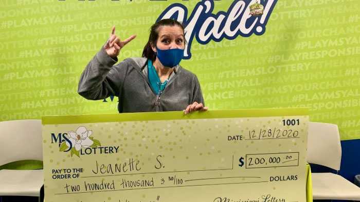 Jeanette S. holds up a check for $200,000.