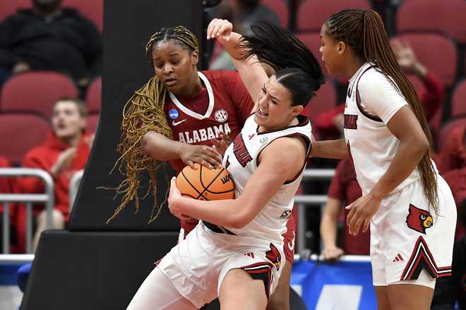 Louisville forward Elif Istanbulluoglu, center, battles Alabama forward Essence Cody, left, for possession of the ball during the second half in the second round of the NCAA college basketball tournament, Monday, March 23, 2026, in Louisville, Ky.