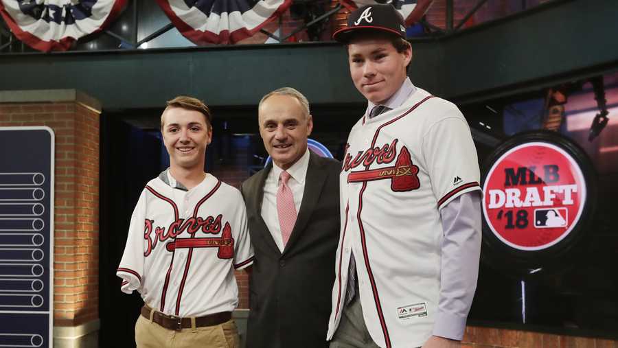 Carter Stewart, a pitcher from Eau Gallie High School in Florida, right, poses for photos with Baseball commissioner Rob Manfred, center, and Luke Terry, left, after being selected eighth by the Atlanta Braves during the first round of the Major League Baseball draft Monday, June 4, 2018, in Secaucus, N.J. 