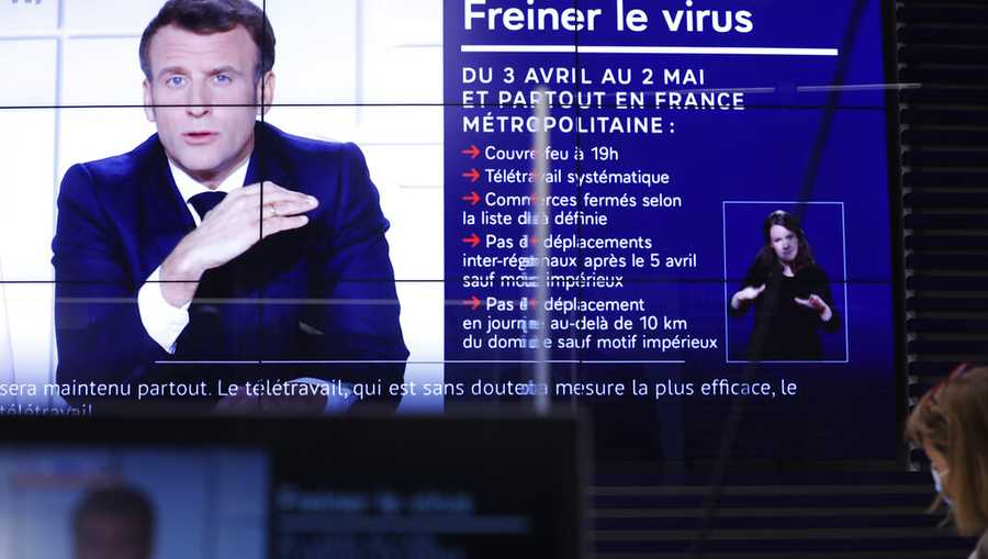 Local prefect Josiane Chevalier, right, watches French President Emmanuel Macron addressing the nation, in the local government building in Strasbourg, eastern France, Wednesday, March 31, 2021. French President Macron announced 3-week nationwide school closure, domestic travel ban amid virus surge. (AP Photo/Jean-Francois Badias)