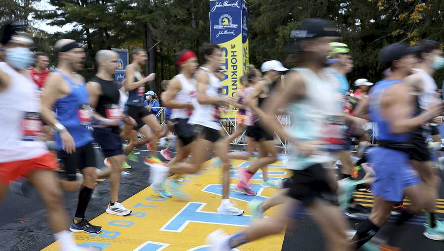 Runners cross the starting line of the 125th Boston Marathon, Monday, Oct. 11, 2021, in Hopkinton, Mass. (AP Photo/Mary Schwalm)