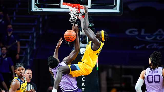 Marquette forward Kur Kuath (35) finishes a dunk over Kansas State forward Kaosi Ezeagu (20) during the second half of an NCAA college basketball game Wednesday, Dec. 8, 2021,in Manhattan, Kan. At left is Marquette forward Justin Lewis and at right is Kansas State guard Mike McGuirl. Marquette won 64-63.