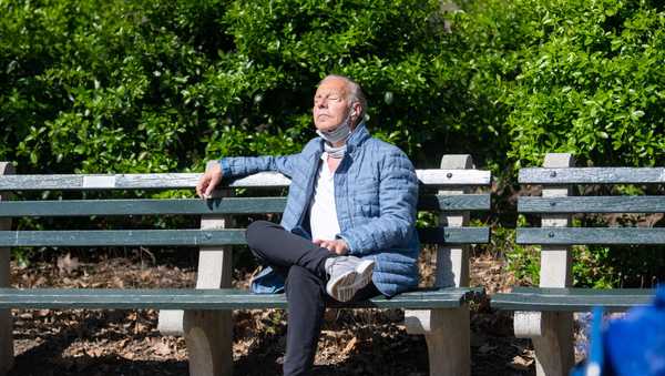 A man pulls down his masks to enjoy the sunshine in Central Park amid the coronavirus pandemic on April 8, 2021 in New York City.