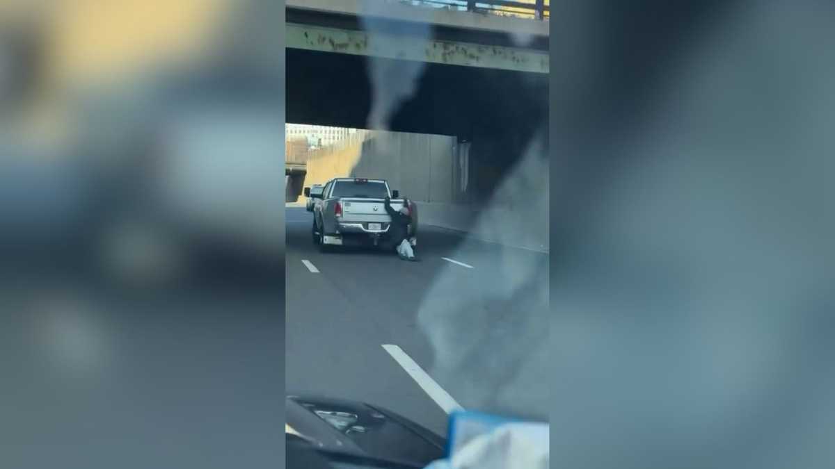 Watch: Man clings to back of pickup truck on Mass Pike