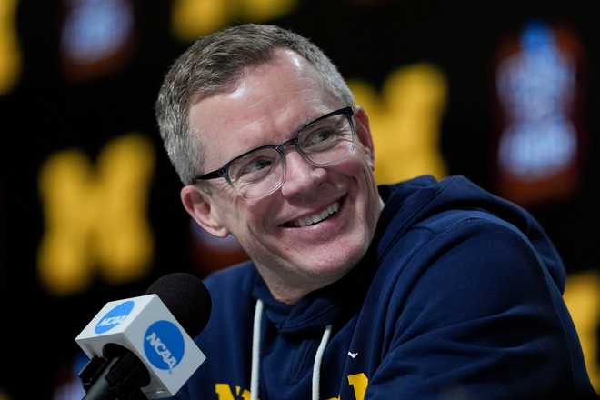 Michigan head coach Dusty May speaks during a news conference ahead of a national championship NCAA college basketball tournament game against UConn at the Final Four, Sunday, April 5, 2026, in Indianapolis.