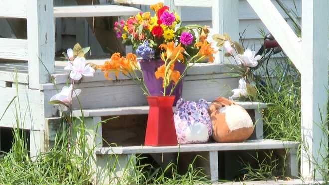 Flowers and stuffed animals were placed on the steps of a home on Highland Avenue in Mechanic Falls, Maine, where three people were found dead on July 27, 2024.