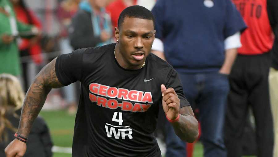 Mecole Hardman runs a football drill with New England Patriot coach Bill Belichick, rear right, watching during Georgia Pro Day, Wednesday, March 20, 2019, in Athens, Ga. (AP Photo/John Amis)