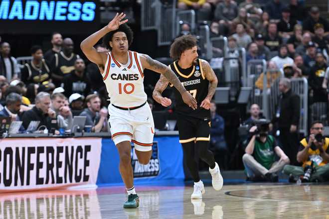 Miami's Tru Washington (10) celebrates after making a 3-point basket as Missouri's Jayden Stone, right, is seen in the background during the first half in the first round of the NCAA college basketball tournament, Friday, March 20, 2026, in St. Louis.