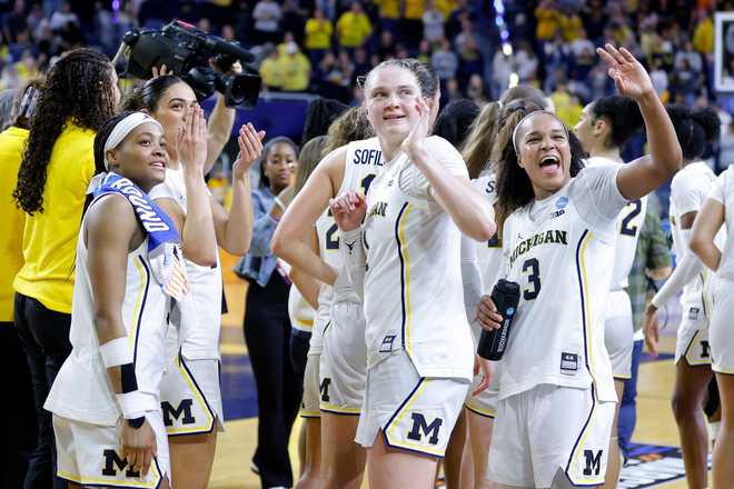 Michigan players, including Brooke Quarles Daniels, left, Olivia Olson, center, and Mila Holloway, right, celebrate in the first round of the NCAA college basketball tournament against Holy Cross, Friday, March 20, 2026, in Ann Arbor, Mich.