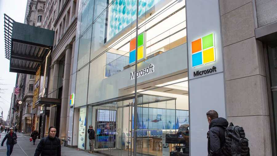 People walk past a Microsoft store entrance with the company's logo on top in Midtown Manhattan at 5th Avenue in New York City, on November 11, 2019.