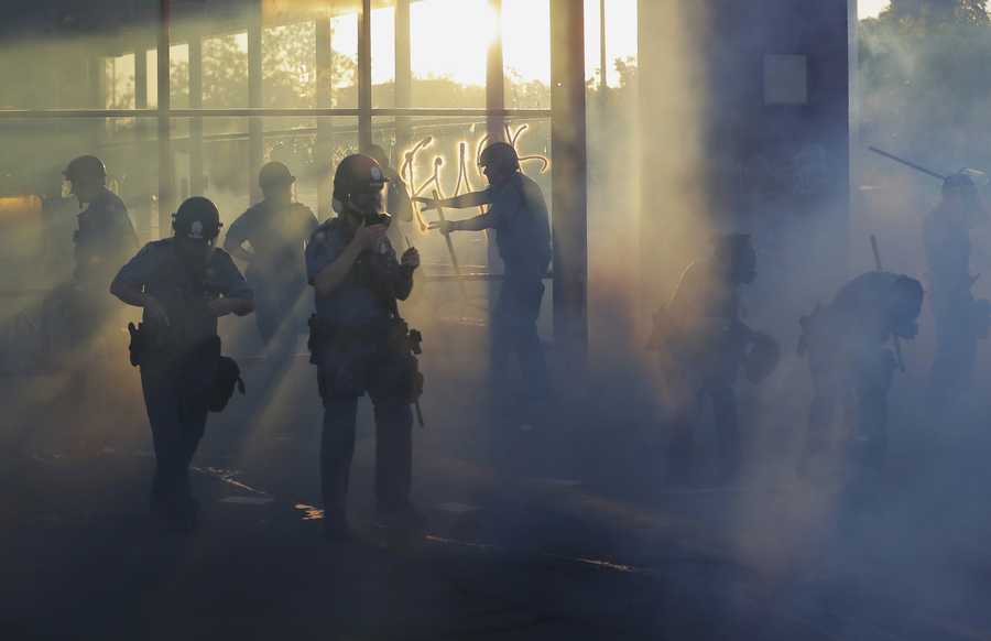 Police move through an area during demonstrations Thursday, May 28, 2020, in St. Paul, Minn.