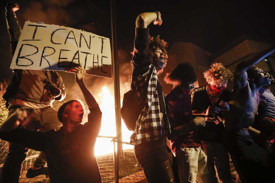 Protestors demonstrate outside of a burning Minneapolis 3rd Police Precinct, Thursday, May 28, 2020, in Minneapolis.
