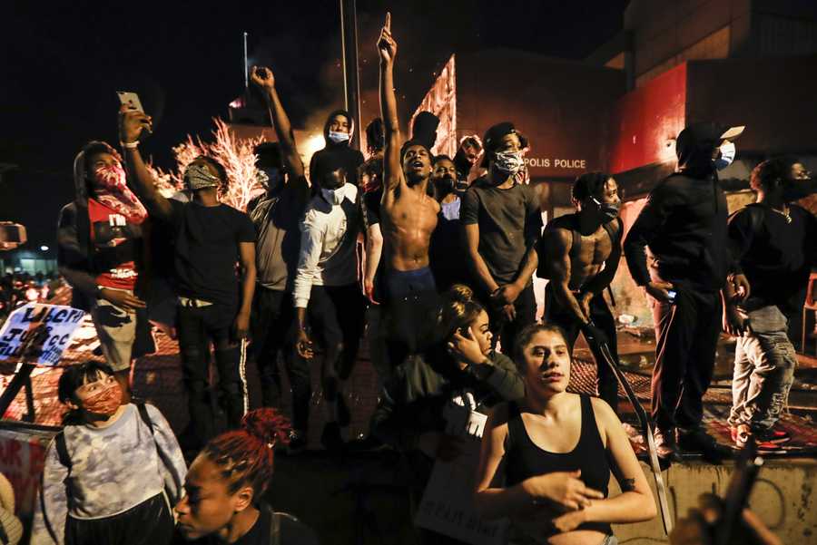 Protestors demonstrate outside of a burning Minneapolis 3rd Police Precinct, Thursday, May 28, 2020, in Minneapolis.
