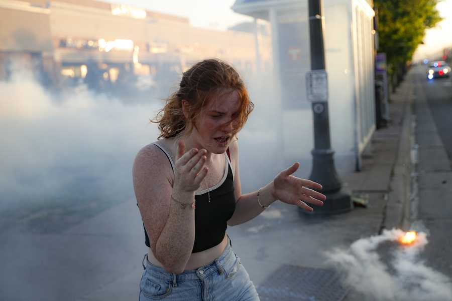 A protestor reacts as she walks through a cloud of tear gas, Thursday, May 28, 2020, in St. Paul, Minn.