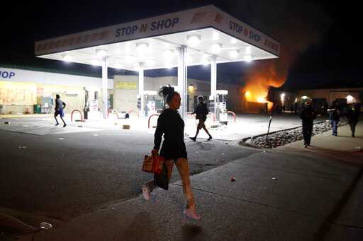 People loot a convenience store Friday, May 29, 2020, in Minneapolis. Protests continued following the death of George Floyd, who died after being restrained by Minneapolis police officers on Memorial Day.