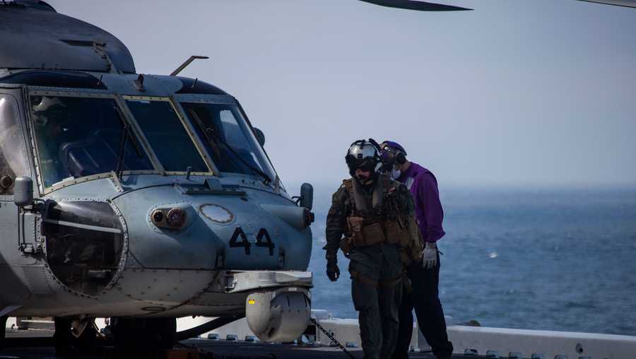 A U.S. Navy MH-60 Seahawk pilot returns to the amphibious assault ship USS Makin Island (LHD-8) during ongoing search and rescue operations following an AAV-P7/A1 assault amphibious vehicle mishap off the coast of Southern California, July 30.