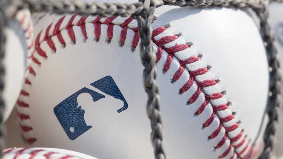 A close-up baseball with the MLB logo is shown.
