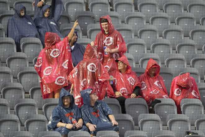 Fans wait in the rain for the delayed start of the MLB Speedway Classic baseball game between the Atlanta Braves and the Cincinnati Reds at Bristol Motor Speedway in Bristol, Tenn., Saturday, Aug. 2, 2025.