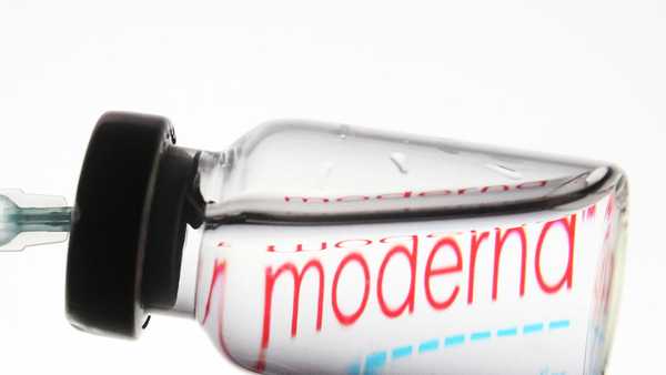 A medical syringe and a vial in front of the Moderna logo are seen in this creative illustrative photo. (Photo illustration by STR/NurPhoto via Getty Images)