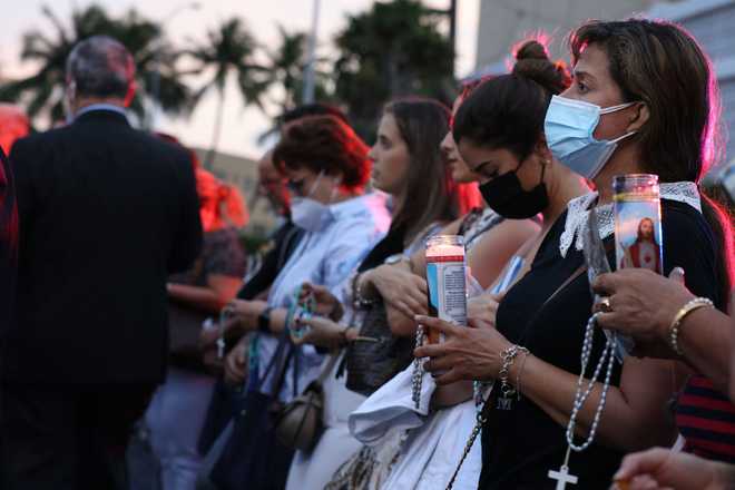 People&#x20;gather&#x20;at&#x20;the&#x20;memorial&#x20;site&#x20;for&#x20;victims&#x20;of&#x20;the&#x20;collapsed&#x20;12-story&#x20;Champlain&#x20;Towers&#x20;South&#x20;condo&#x20;building&#x20;to&#x20;pray&#x20;the&#x20;rosary&#x20;on&#x20;July&#x20;07,&#x20;2021&#x20;in&#x20;Surfside,&#x20;Florida.