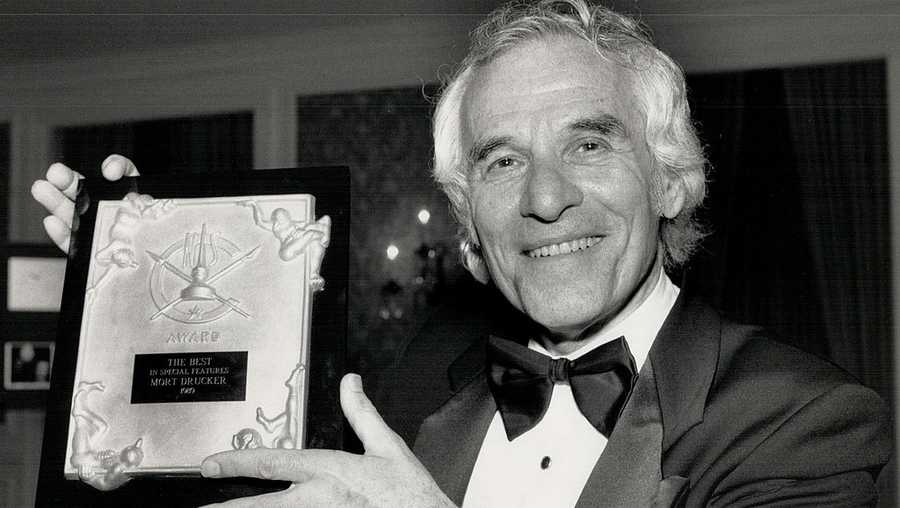 Cartoonist Mort Drucker holds an award for special features in 1989.