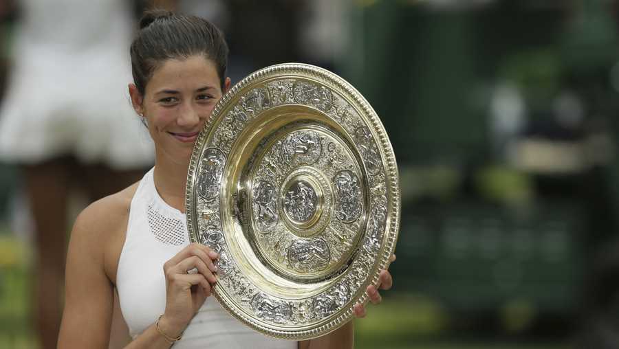 Spain's Garbine Muguruza holds up the trophy after defeating Venus Williams in the women's final at Wimbledon on July 15, 2017. 