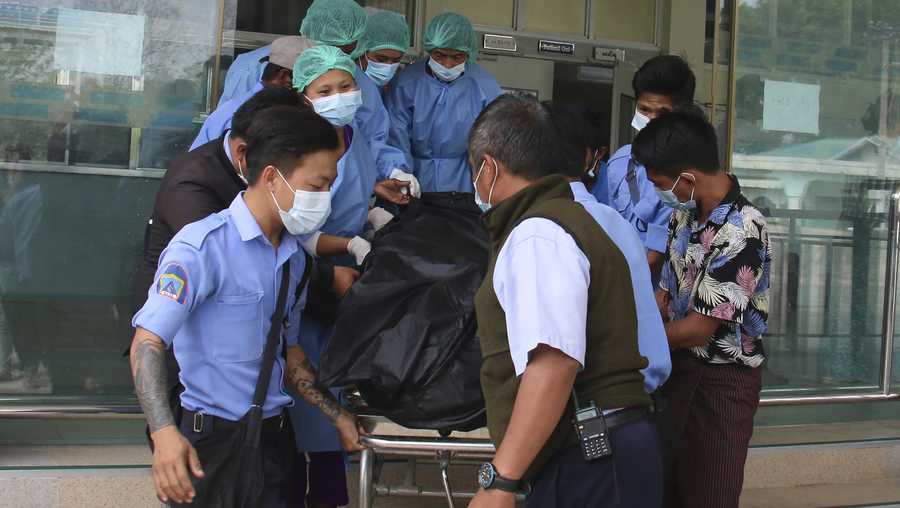 A body bag, containing the remains of a young woman, is brought out of the 1000-Bed General Hospital, in Naypyitaw, Myanmar Friday, Feb. 19, 2021.