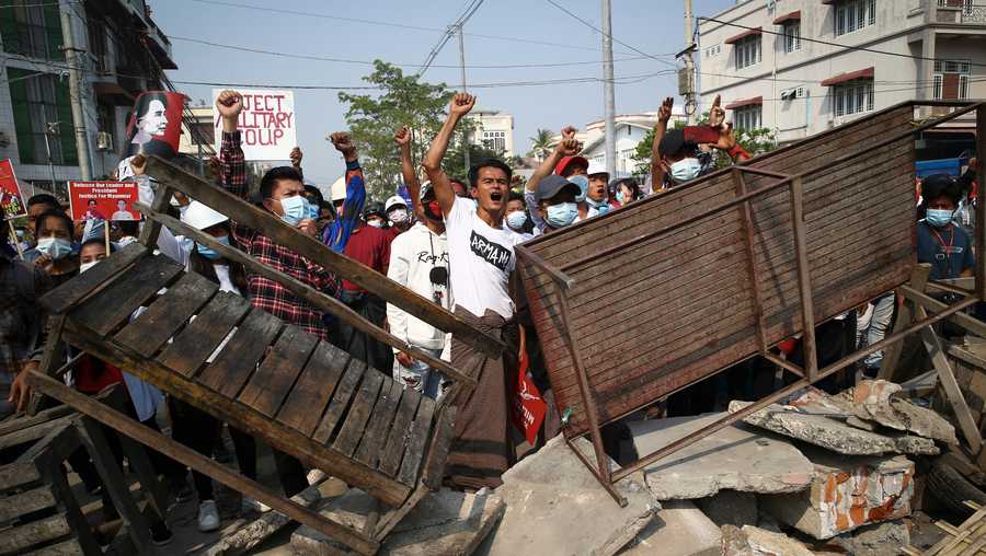 Protesters shout slogans as police arrive during a protest against the military coup in Mandalay, Myanmar, Sunday, Feb. 28, 2021. Police in Myanmar escalated their crackdown on demonstrators against this month's military takeover, deploying early and in force on Saturday as protesters sought to assemble in the country's two biggest cities and elsewhere.