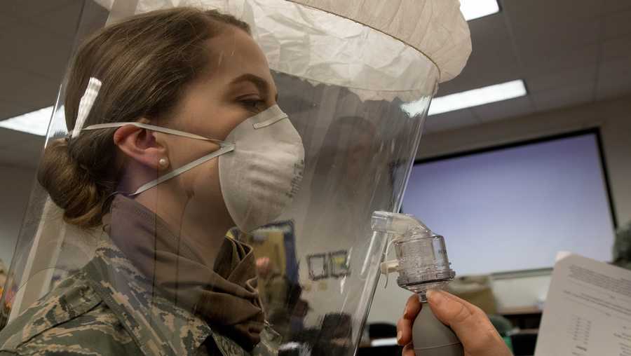 U.S. Airman Master Sgt. Nicki Porter with the 101st Air Refueling Wing, Maine Air National Guard, breaths in during her N95 fit test to ensure she can’t taste the spray, indicating a good seal.