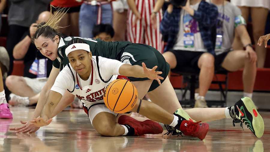 North Carolina State&apos;s Zoe Brooks (35) scrambles for the loose ball with Michigan State&apos;s Grace VanSlooten, back, during the first half in the second round of the NCAA college basketball tournament in Raleigh, N.C.
