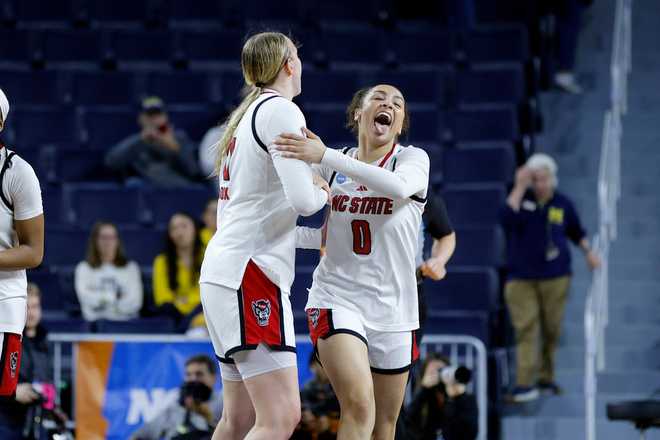 North Carolina State guard Devyn Quigley (0) and forward Maddie Cox, center left, celebrate after defeating Tennessee in the first round of the NCAA college basketball tournament, Friday, March 20, 2026, in Ann Arbor, Mich.