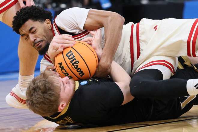Nebraska guard Jamarques Lawrence, top, and Vanderbilt forward Tyler Nickel, bottom, try to control the ball during the first half in the second round of the NCAA college basketball tournament, Saturday, March 21, 2026, in Oklahoma City.