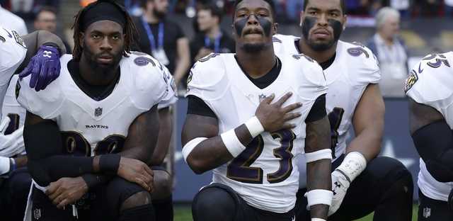 Baltimore Ravens strong safety Tony Jefferson (23) and Baltimore Ravens outside linebacker Matt Judon, left, kneel down with teammates during the playing of the U.S. national anthem before an NFL football game against the Jacksonville Jaguars at Wembley Stadium in London, Sunday Sept. 24, 2017. 