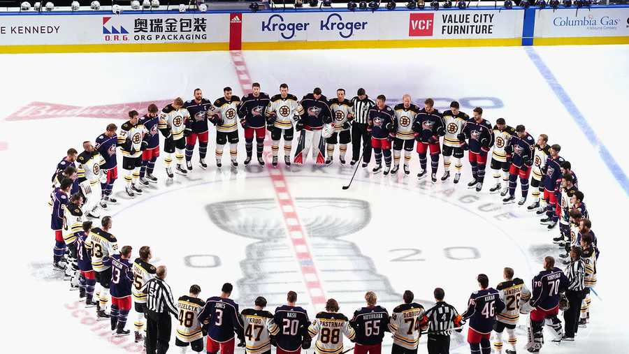 The Boston Bruins and the Columbus Blue Jackets gather at center ice prior to their exhibition game before the 2020 NHL Stanley Cup Playoffs at Scotiabank Arena on July 30, 2020 in Toronto, Ontario, Canada.