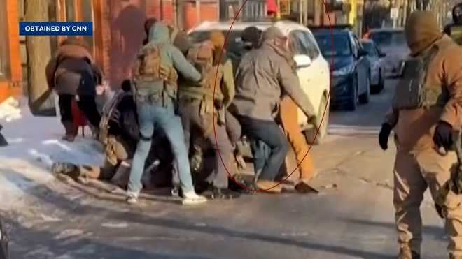 Officer seen walking away from the scuffle with something in hand.