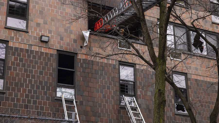 Ladders are seen erected beside the apartment building in the Bronx after a fire occurred on Sunday, Jan. 9, 2022, in New York. (AP Photo/Yuki Iwamura)