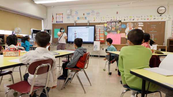 NEW YORK, NEW YORK - SEPTEMBER 27: Melissa Wong, a teacher at Yung Wing School P.S. 124 gives a lesson to her masked students in their classroom on September 27, 2021 in New York City.
