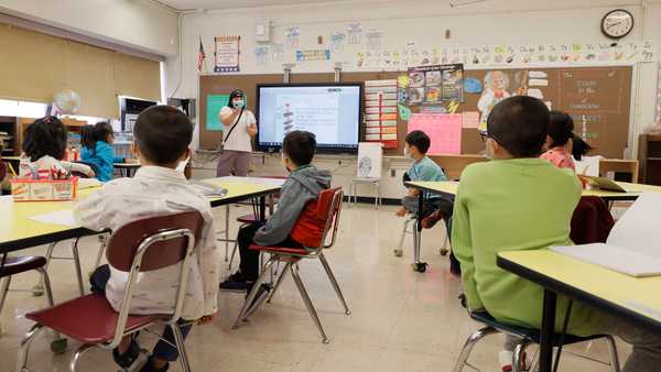 NEW YORK, NEW YORK - SEPTEMBER 27: Melissa Wong, a teacher at Yung Wing School P.S. 124 gives a lesson to her masked students in their classroom on September 27, 2021 in New York City.