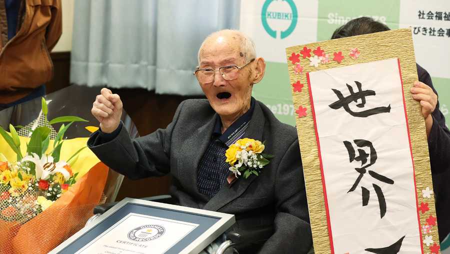 In this Japan Pool picture received via Jiji Press on February 12, 2020, 112-year-old Japanese man Chitetsu Watanabe poses next to calligraphy reading in Japanese 'World Number One' after he was awarded as the world's oldest living male in Joetsu, Niigata prefecture. 