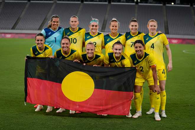 Australia&#x20;players&#x20;pose&#x20;for&#x20;a&#x20;group&#x20;photo&#x20;with&#x20;an&#x20;indigenous&#x20;flag&#x20;prior&#x20;to&#x20;women&#x27;s&#x20;soccer&#x20;match&#x20;against&#x20;New&#x20;Zealand&#x20;at&#x20;the&#x20;2020&#x20;Summer&#x20;Olympics,&#x20;Wednesday,&#x20;July&#x20;21,&#x20;2021,&#x20;in&#x20;Tokyo.