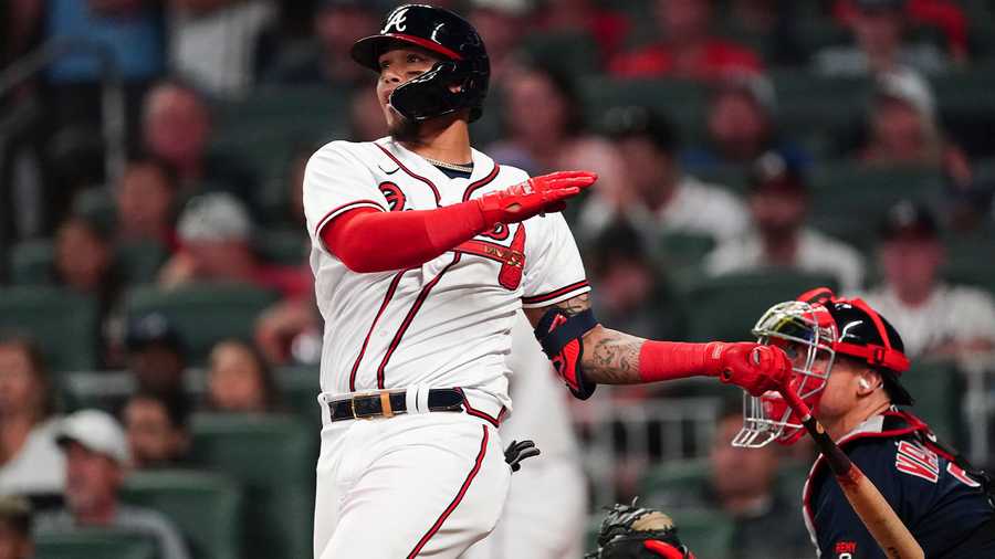 Atlanta Braves' Orlando Arcia (11) follows through on a two-run walkout home run as Boston Red Sox catcher Christian Vazquez (7) looks on in the ninth inning of a baseball game Wednesday, May 11, 2022, in Atlanta.