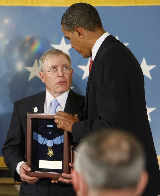 President Barack Obama presents the Medal of Honor to Paul Monti, father of Army Sgt. 1st. Class Jared C.Monti  x20;of Raynham, Mass.  , Thursday, Sept. 17, 2009, during a ceremony in the East Room of the White House in Washington.