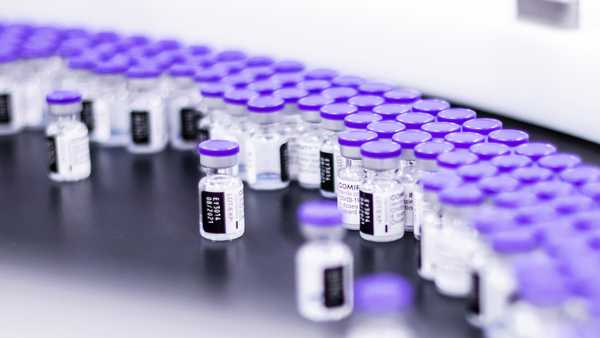 In this March 2021 photo provided by Pfizer, vials of the Pfizer-BioNTech COVID-19 vaccine are prepared for packaging at the company's facility in Puurs, Belgium.