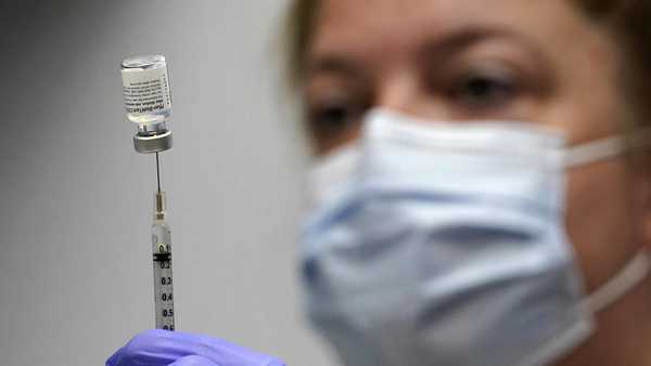 In this March 2, 2021, file photo, pharmacy technician Hollie Maloney loads a syringe with Pfizer's COVID-19 vaccine at the Portland Expo in Portland, Maine.