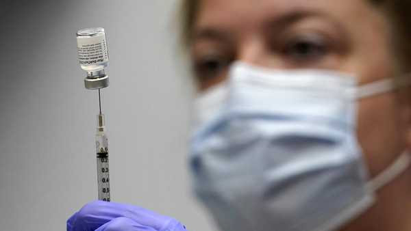 In this March 2, 2021, file photo, pharmacy technician Hollie Maloney loads a syringe with Pfizer's COVID-19 vaccine at the Portland Expo in Portland, Maine.