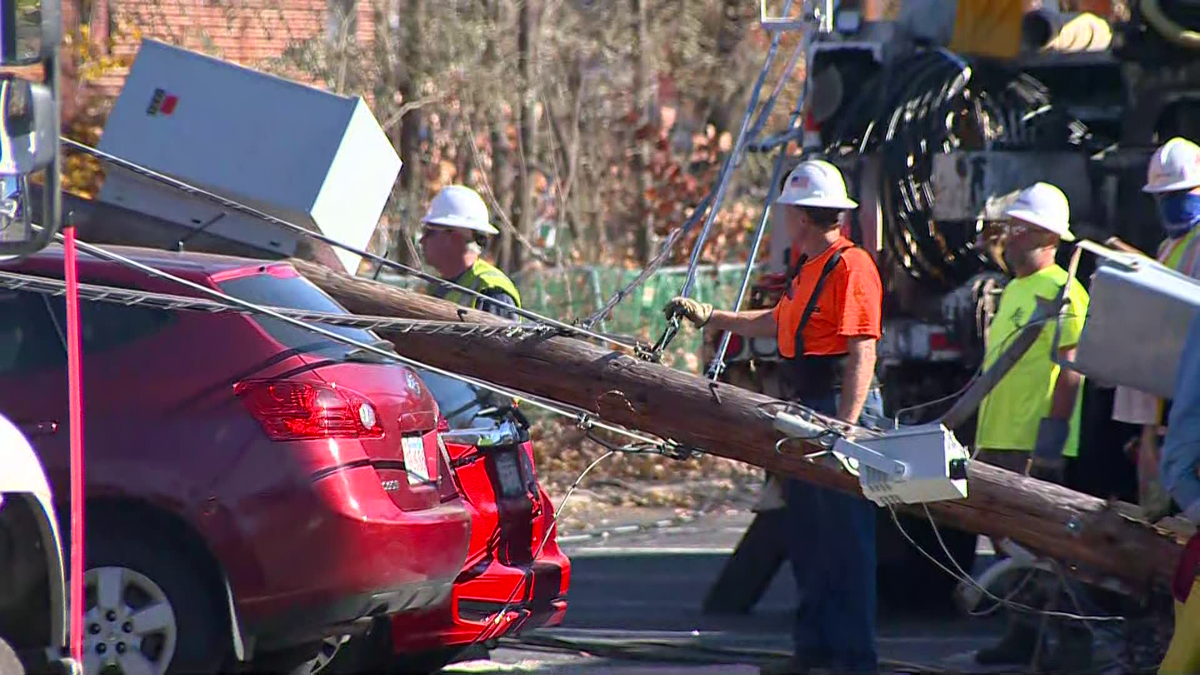 Moving truck snags wires, utility pole falls on brand-new car